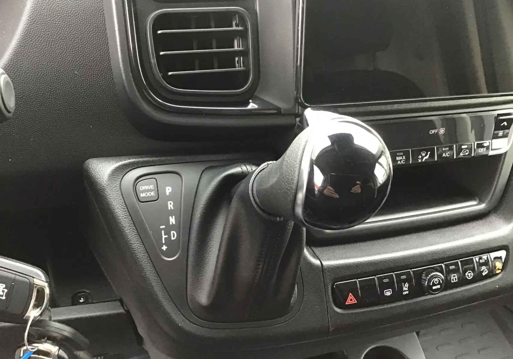 Gros plan sur le levier de vitesses automatique noir et la console centrale du Peugeot Boxer Fourgon blanc 2025.