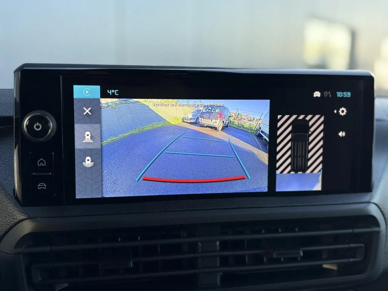 Écran tactile du tableau de bord montrant la caméra de recul et l'affichage du stationnement du Citroën Jumpy gris.