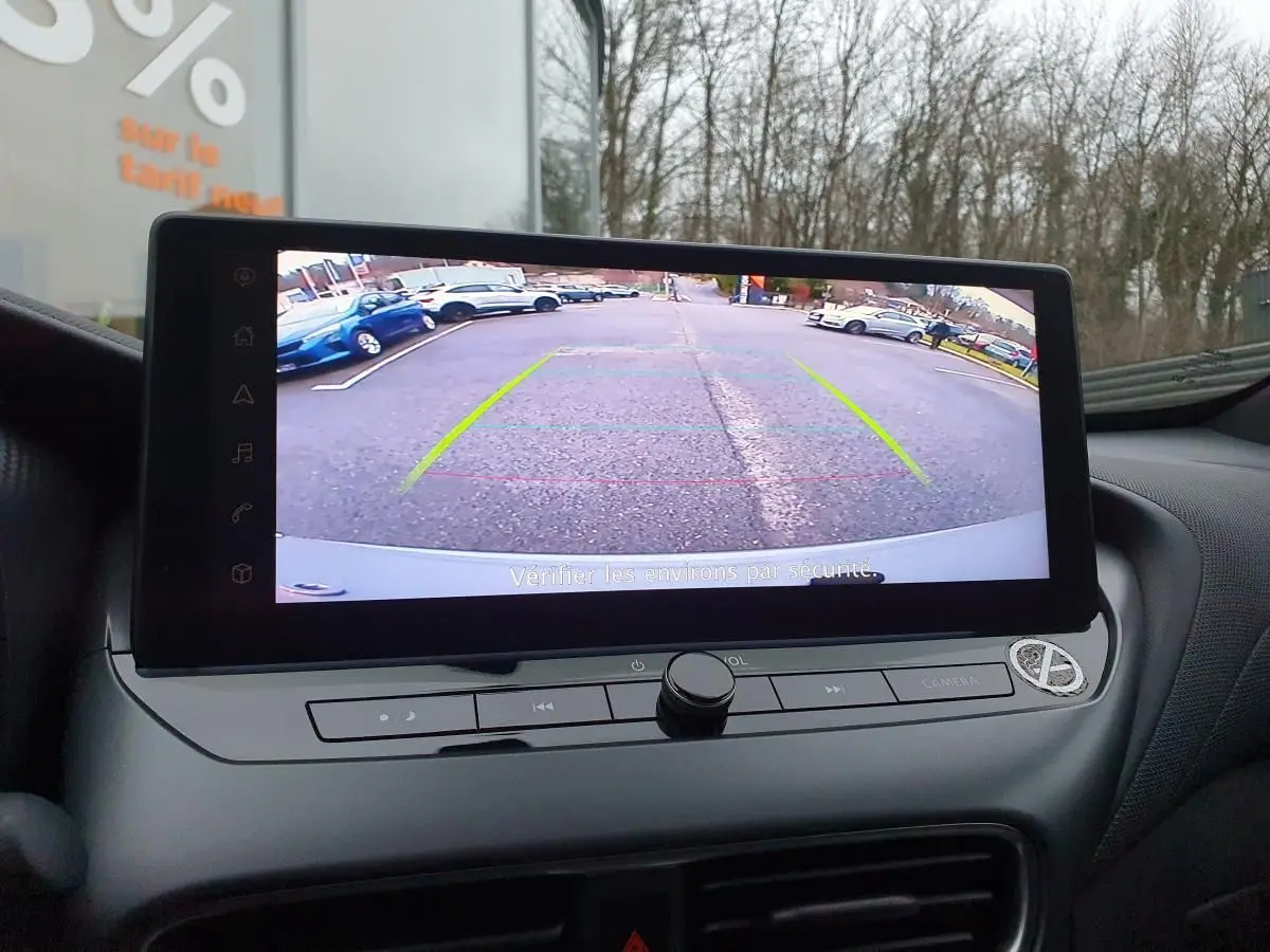 Écran tactile 12,3'' affichant la caméra de recul du Nissan Juke 2025, intérieur avec tableau de bord gris.