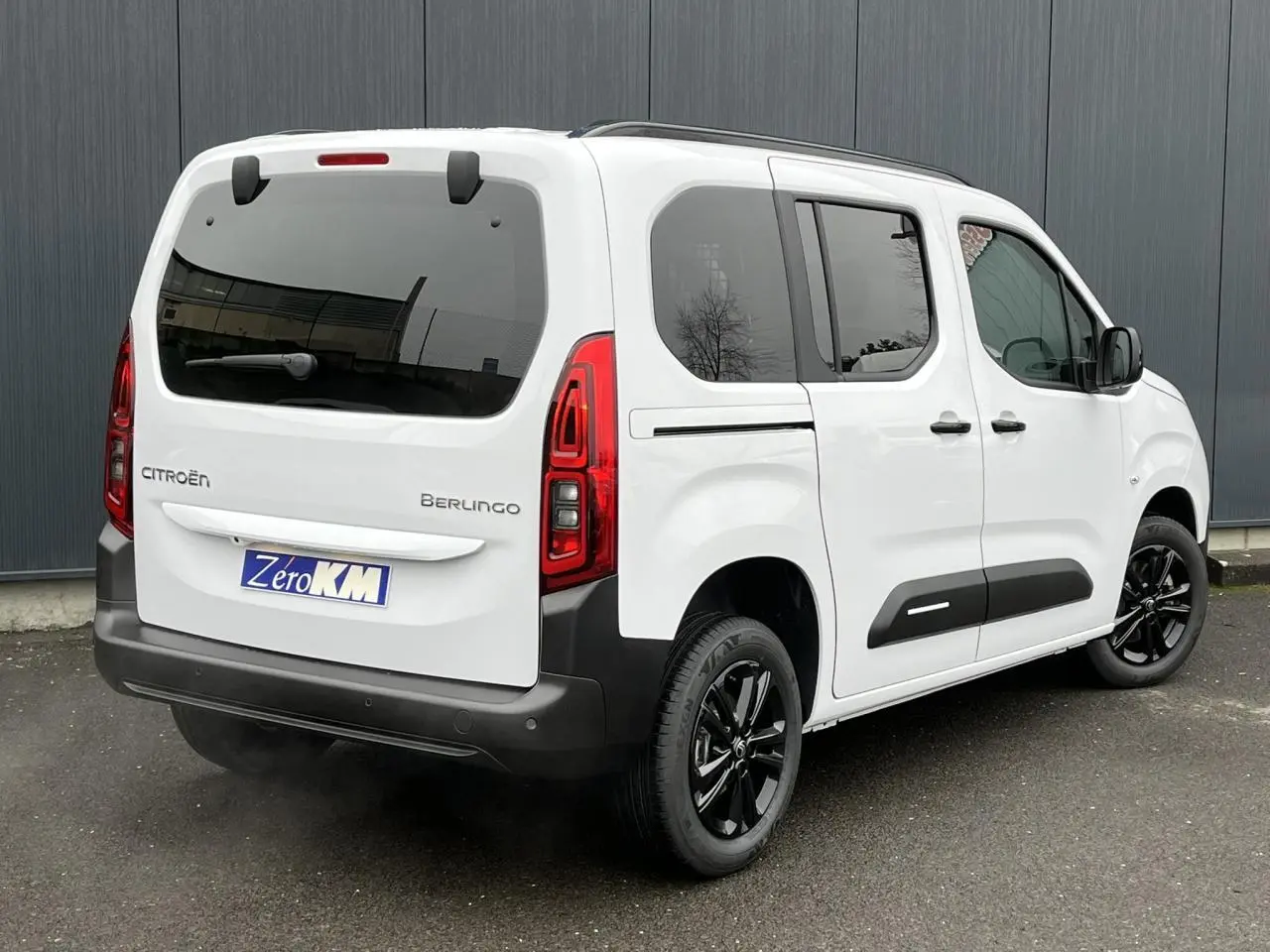 Vue 3/4 arrière droite du Citroën Berlingo blanc Glacier avec jantes alliage noires et lunette arrière ouvrante.