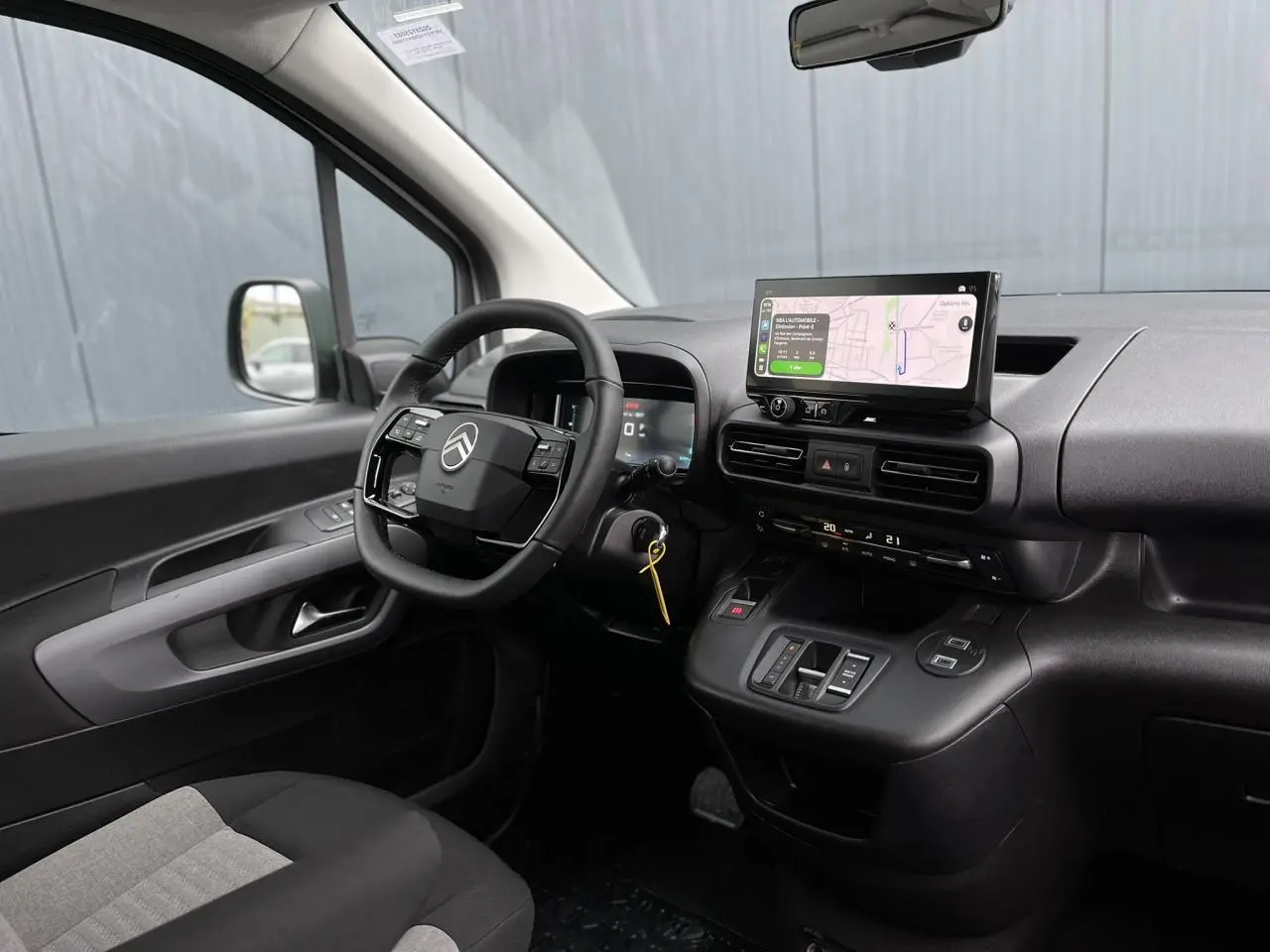 Vue intérieure côté conducteur du Citroën Berlingo Multispace 2025 avec tableau de bord noir et écran tactile GPS.