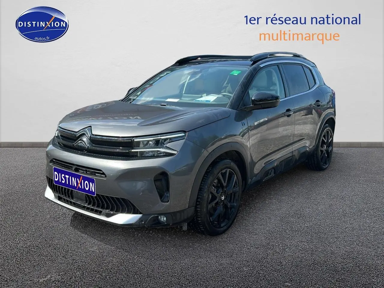 SUV Citroën C5 Aircross gris platinium en 3/4 avant droit avec jantes noires et barres de toit visibles.