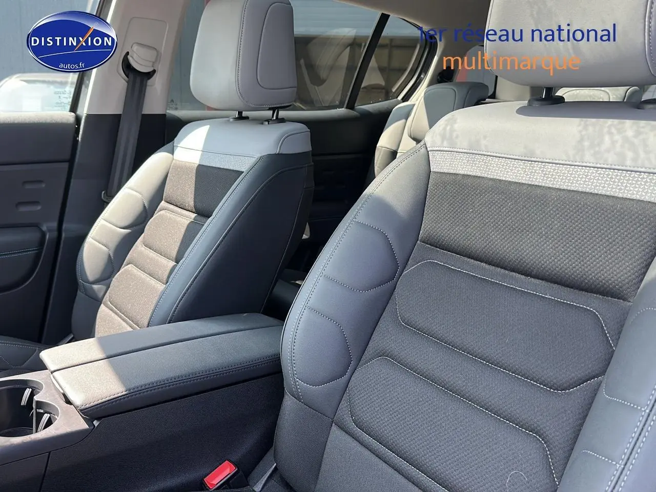 Intérieur du Citroën C5 Aircross 2024, vue sur sièges avant en tissu brun et cuir noir avec accoudoir central.