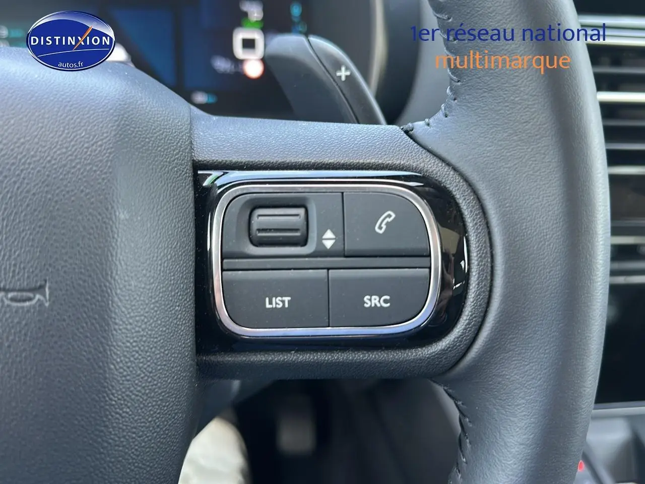 Gros plan sur les commandes gauche du volant cuir du Citroën C5 Aircross gris platinium 2024 hybride rechargeable.