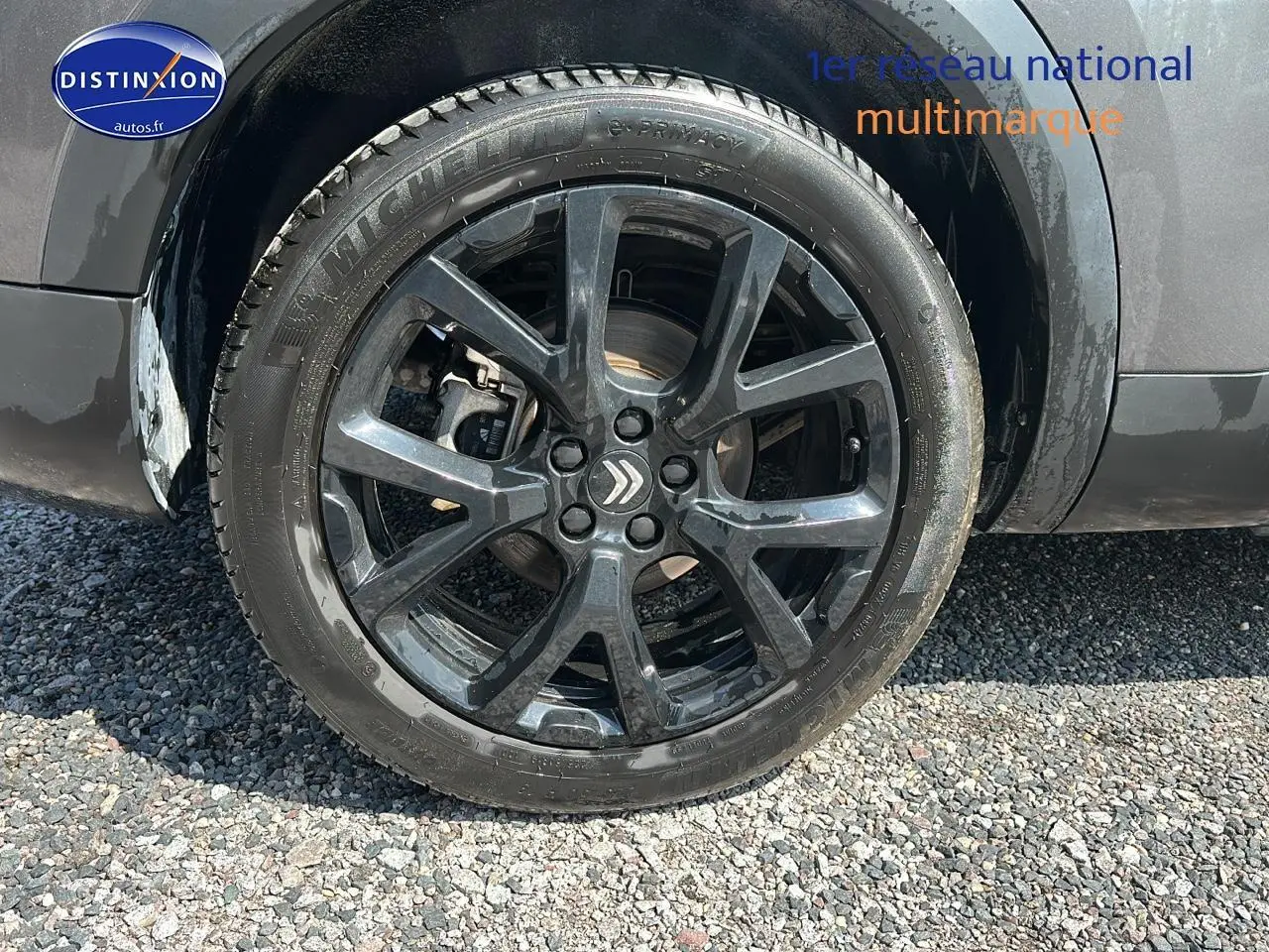 Gros plan sur la roue avant gauche avec jante alliage noire du Citroën C5 Aircross gris platinium 2024 hybride rechargeable.