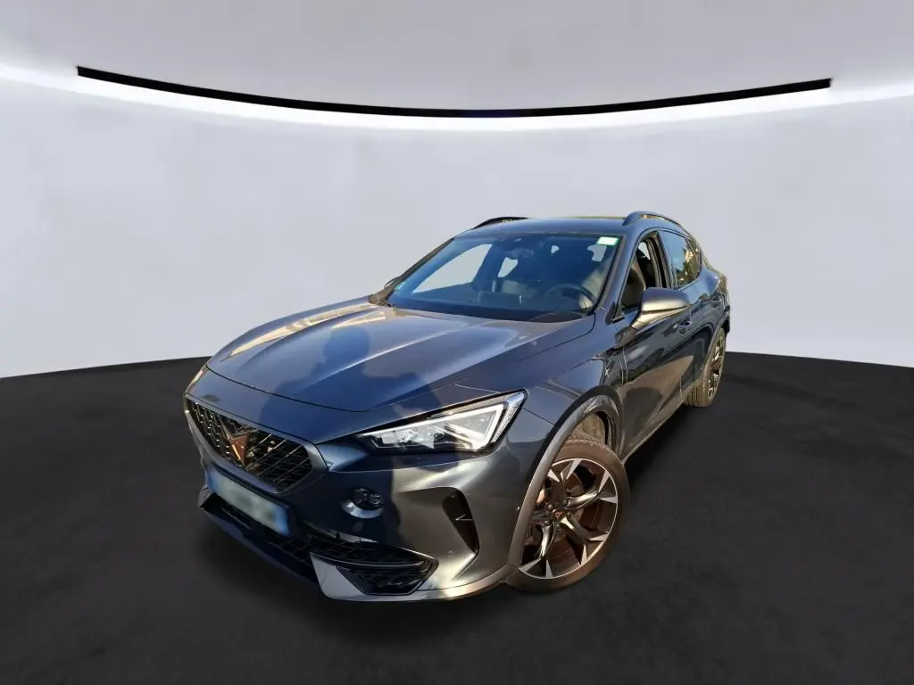 Vue 3/4 avant droite d'une CUPRA Formentor gris foncé 2023 avec jantes alliage et calandre marquée du logo Cupra.