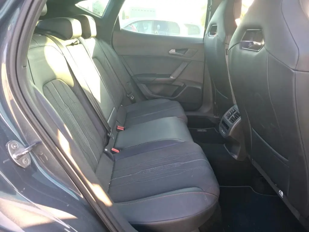 Vue intérieure côté gauche des sièges arrière noirs du CUPRA Formentor gris foncé, mettant en valeur l'espace et les finitions.