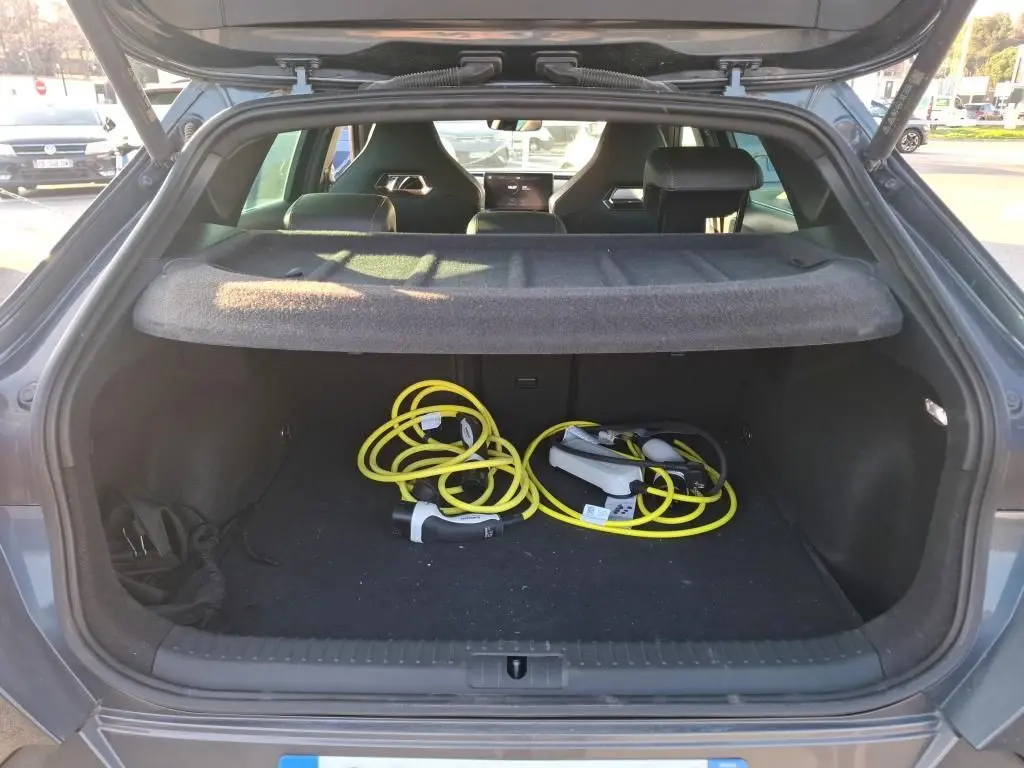 Coffre ouvert vu de l'arrière d'une CUPRA Formentor gris foncé 2023 avec câbles de recharge hybride visibles à l'intérieur.