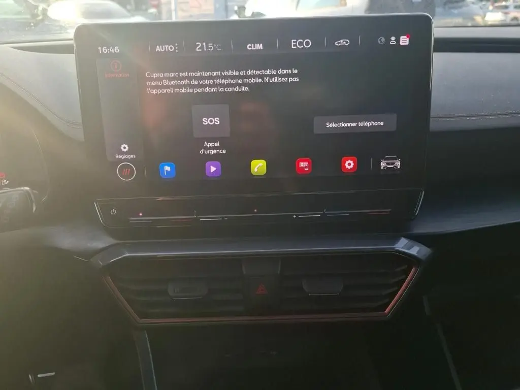 Écran tactile central allumé du tableau de bord d'un CUPRA Formentor gris foncé, affichant le menu Bluetooth et les réglages climatiques.