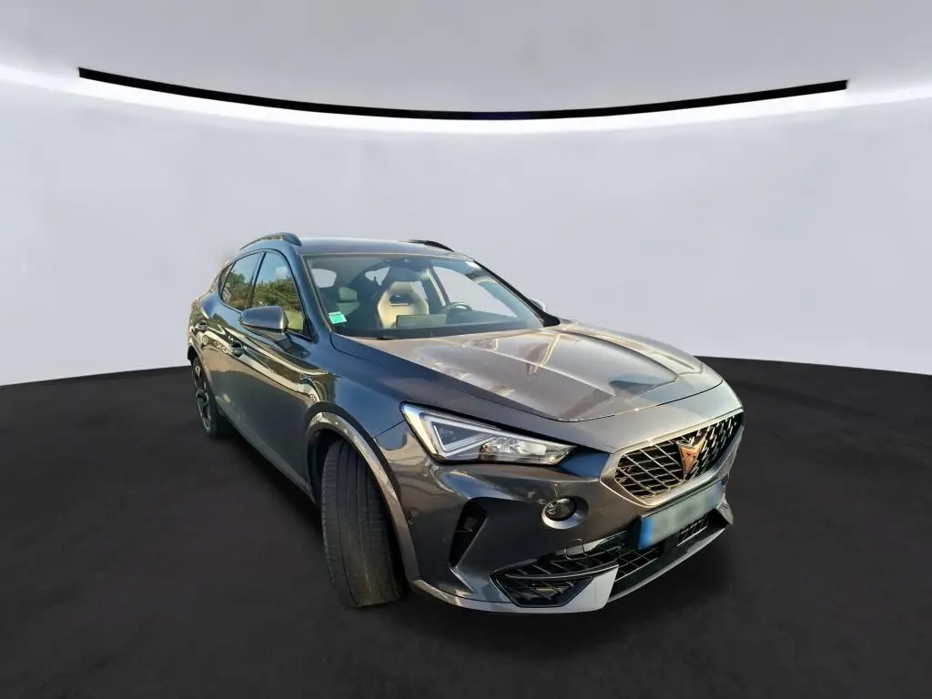 Vue 3/4 avant du CUPRA Formentor gris foncé 2023 avec calandre distinctive et jantes noires, posé sur fond neutre.