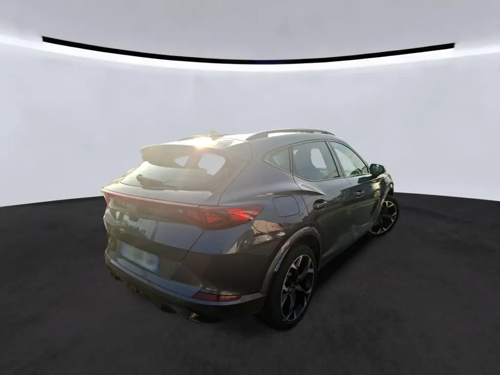 Vue 3/4 arrière droite d'un CUPRA Formentor gris foncé 2023, hybride rechargeable, avec jantes noires et toit ouvrant.
