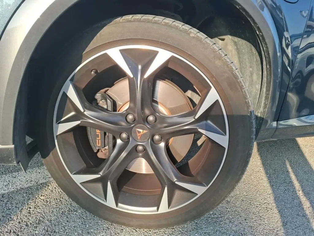 Gros plan sur la roue avant droite gris foncé d'une CUPRA Formentor 1.4 E-HYBRID 245 DSG6 avec jante noire et argentée.