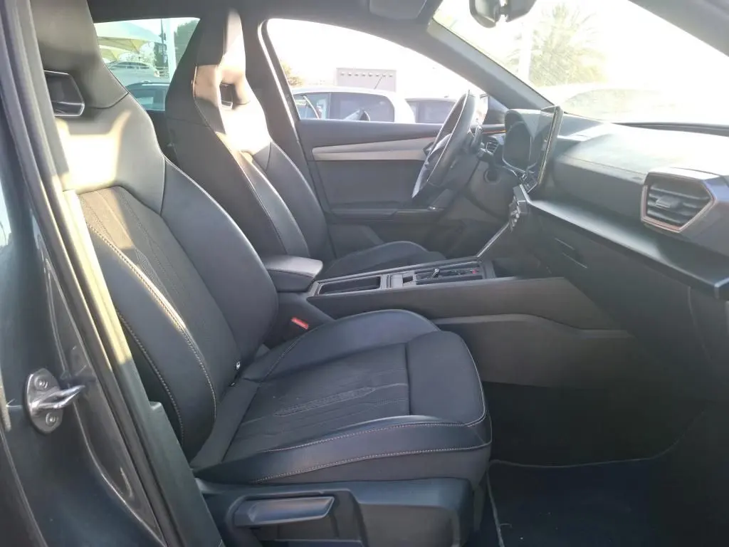 Vue intérieure côté conducteur de la CUPRA Formentor gris foncé 2023, sièges sport noirs et tableau de bord moderne.