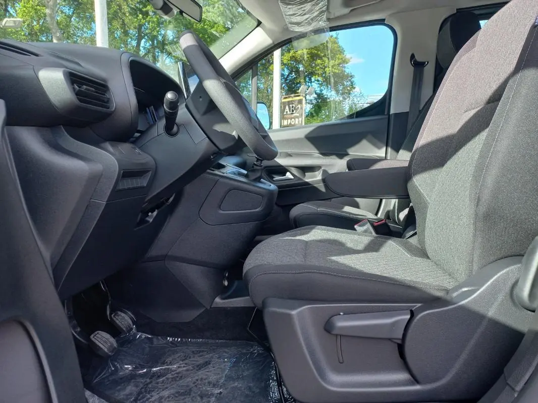 Vue intérieure côté conducteur de l'Opel Combo Life Elegance M 2025, sièges gris et tableau de bord noir.