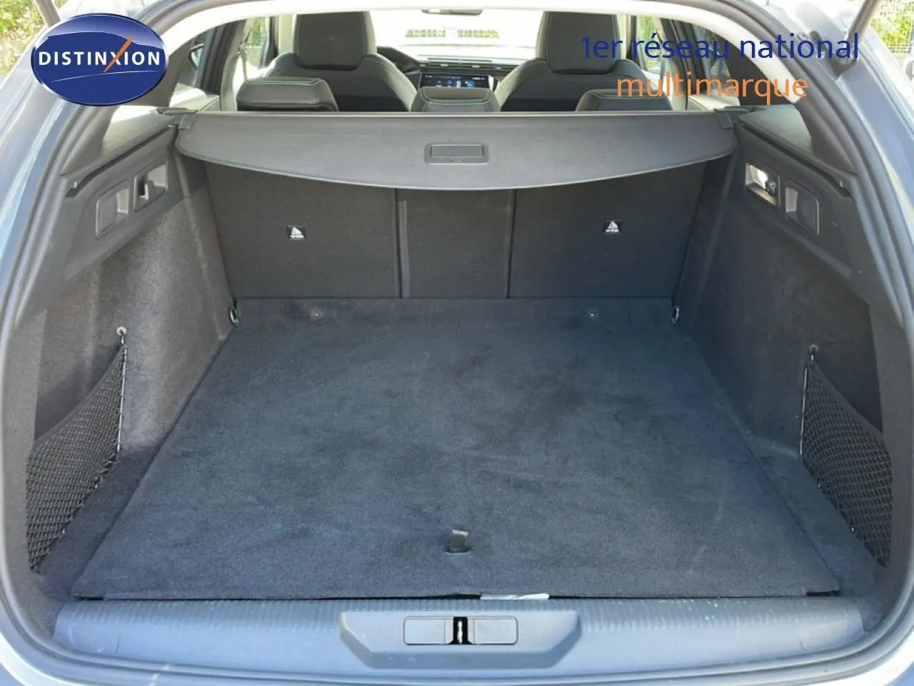 Coffre ouvert vu de l'arrière d'une Peugeot 308 SW gris Artense, montrant un espace de chargement propre et bien agencé.