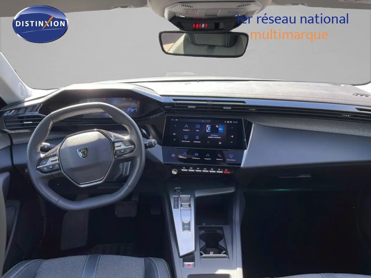 Vue intérieure avant de la Peugeot 308 SW Hybrid 2025, tableau de bord moderne avec écran tactile et volant compact gris noir.