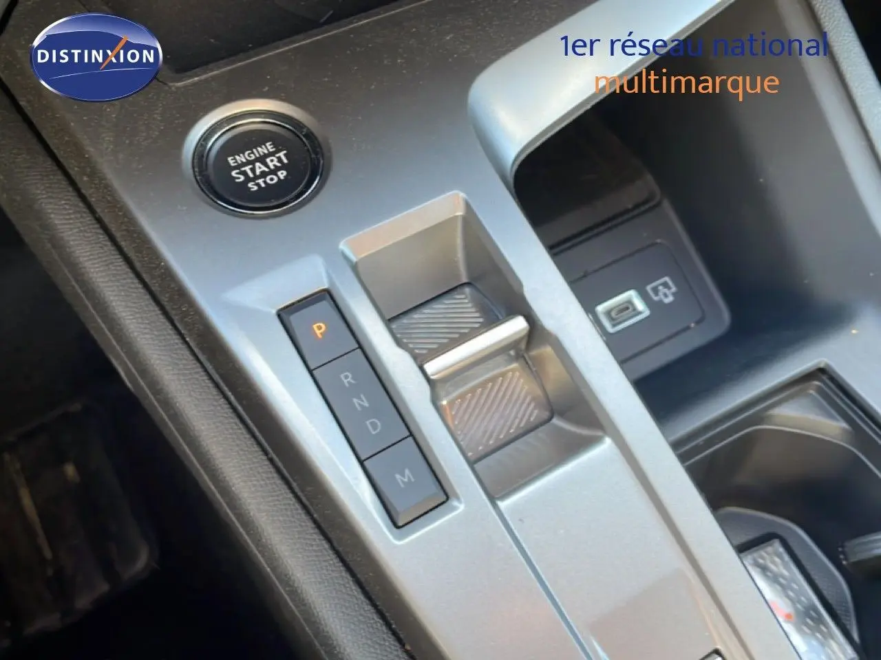 Gros plan sur la console centrale grise du Peugeot 308 SW Hybrid 2025, montrant le bouton start/stop et la commande de boîte automatique.