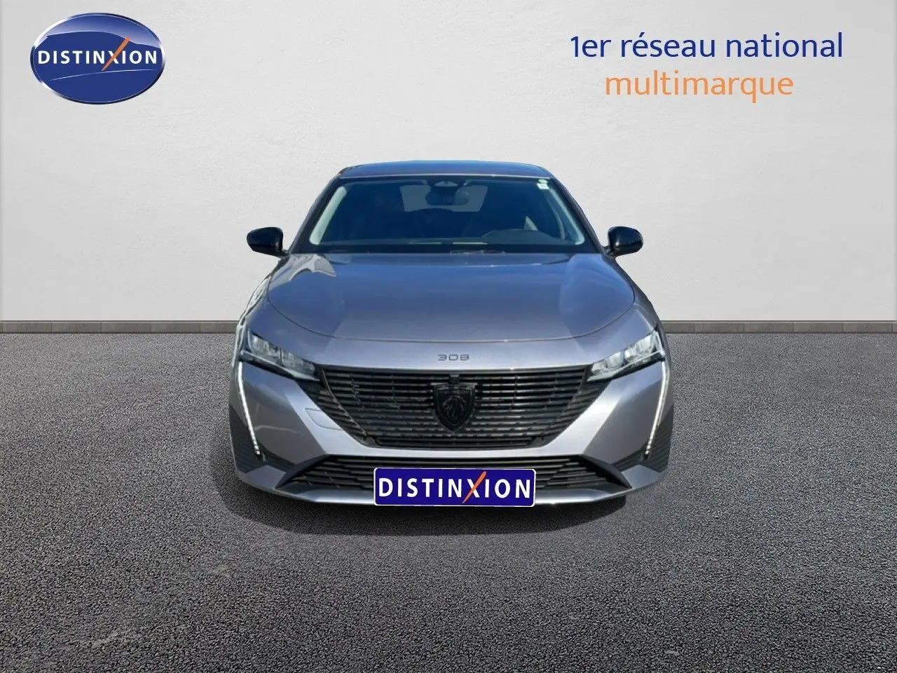 Vue frontale d'une Peugeot 308 SW Hybrid 145ch gris Artense métal, avec calandre noire et feux LED distinctifs.