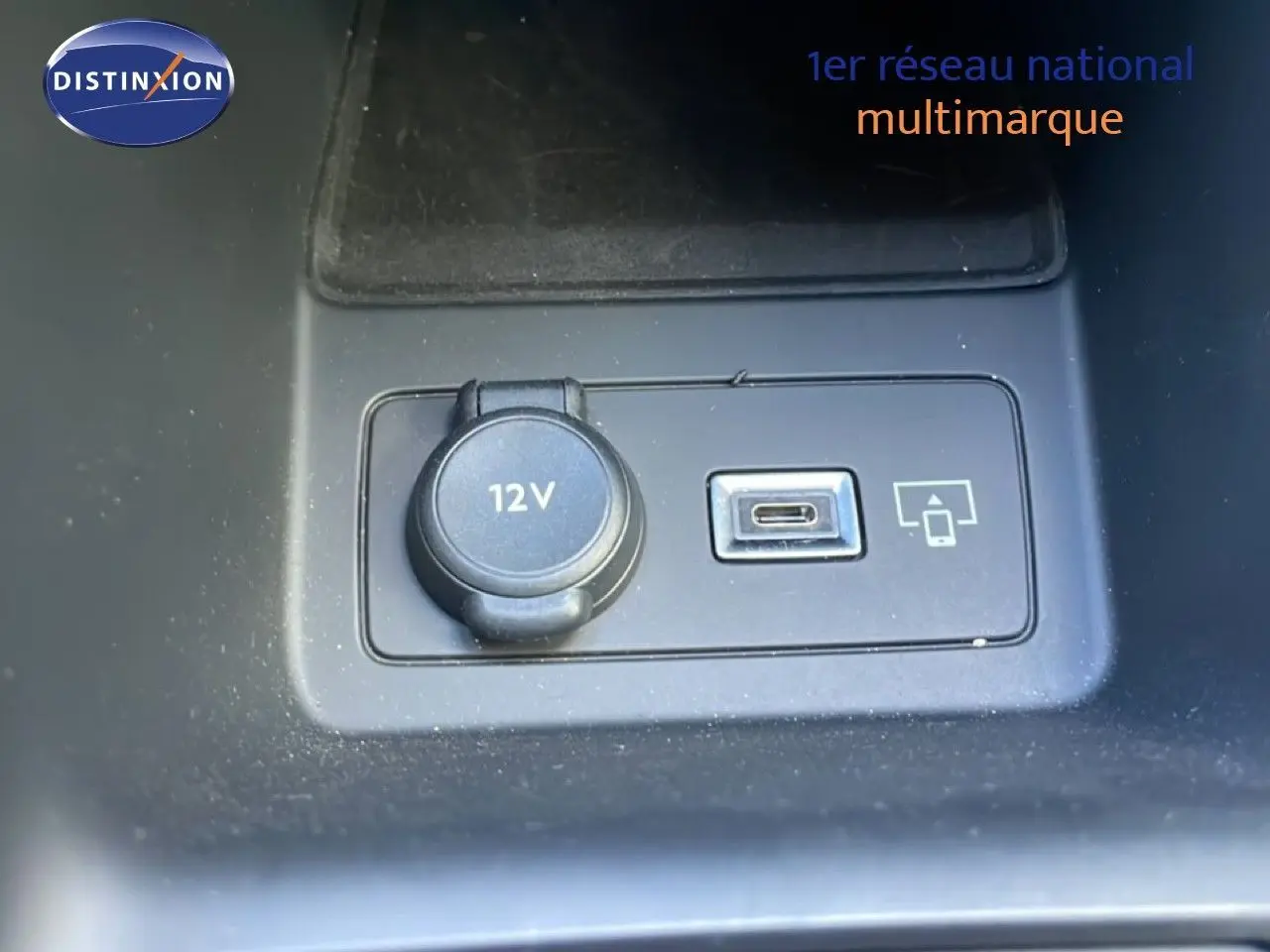Prise 12V et port USB-C en gros plan sur la console centrale d’un Peugeot 308 SW gris Artense 2025.