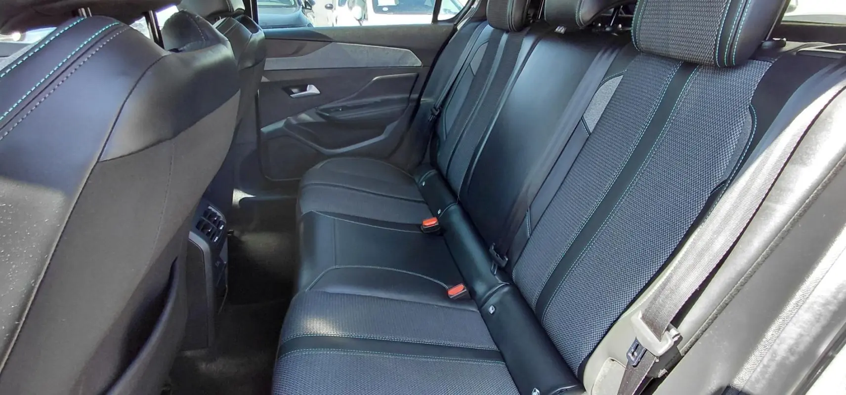 Vue intérieure des sièges arrière en tissu et cuir noir de la Peugeot 308 Hybrid 145 e-DCS6 Allure 2025.