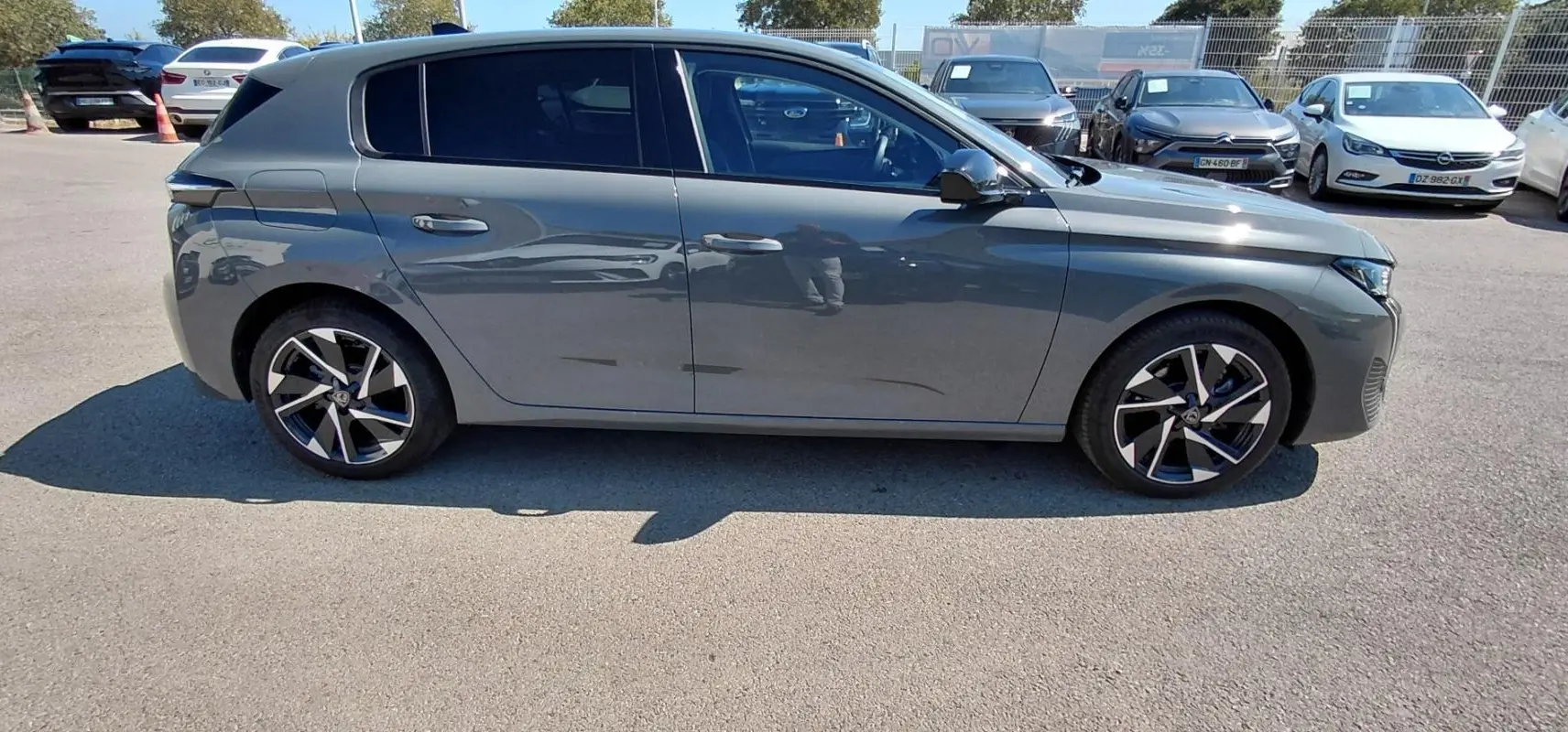 Peugeot 308 Hybrid gris vue de profil côté gauche, avec jantes alliage 17 pouces et vitres teintées.