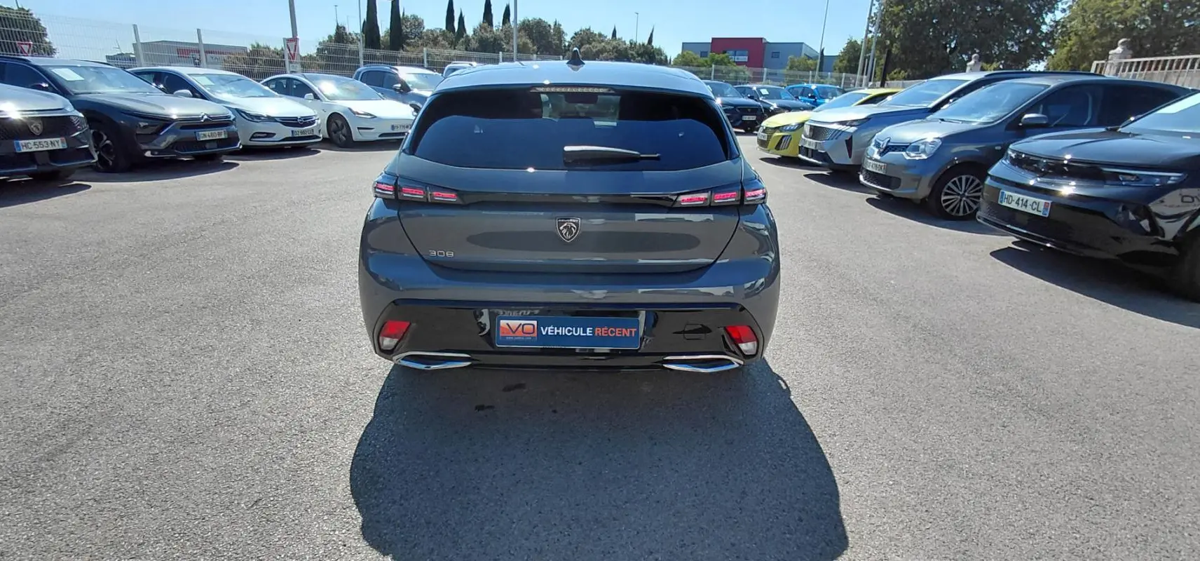 Vue arrière d'une Peugeot 308 gris foncé 2025 avec feux LED et double sortie d'échappement chromée.