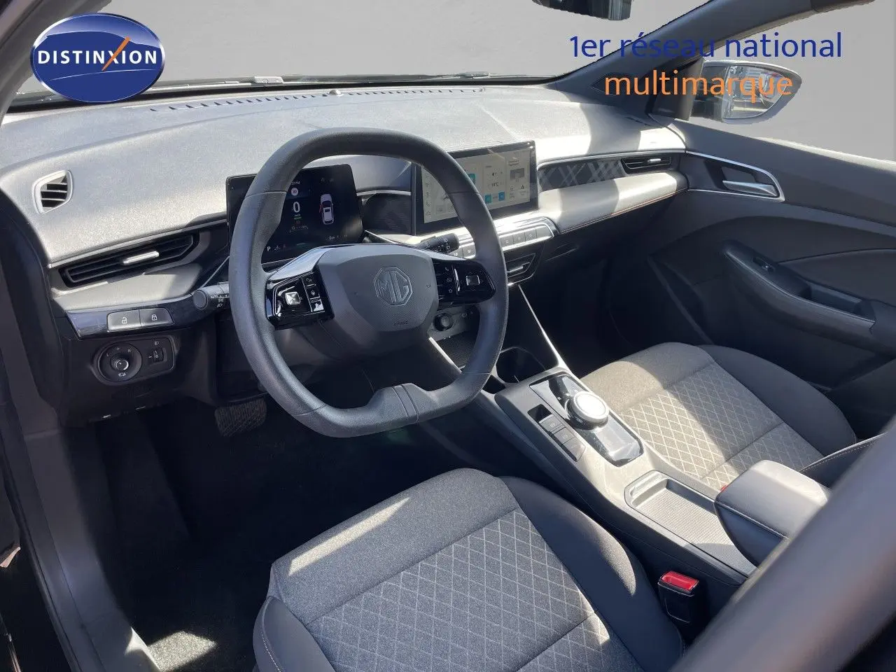 Vue intérieure côté conducteur du MG3 2025 avec tableau de bord numérique et sièges tissu gris à motifs géométriques.