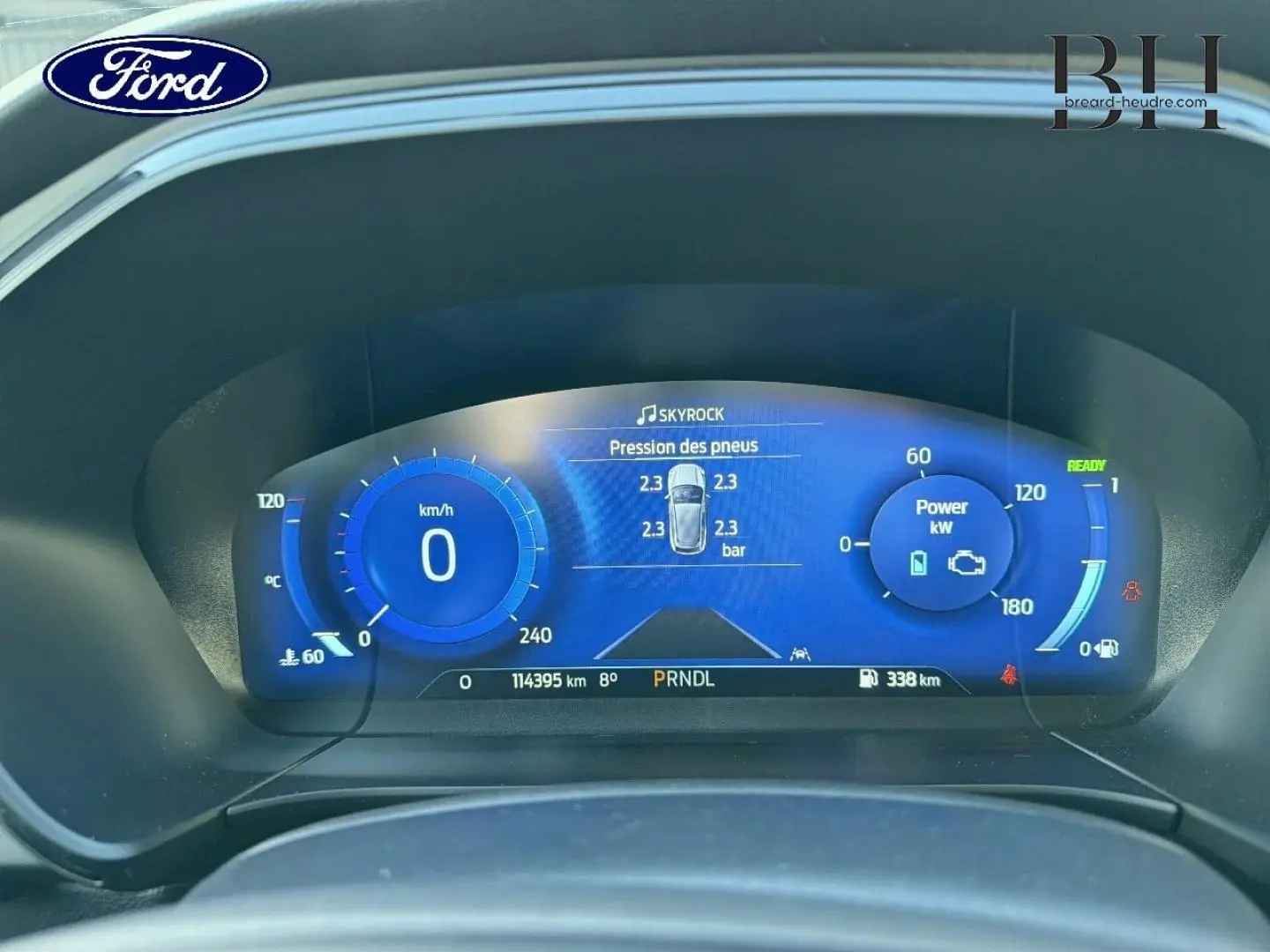 Vue rapprochée du tableau de bord numérique bleu du Ford Kuga 2023 affichant la pression des pneus et la puissance en kW.