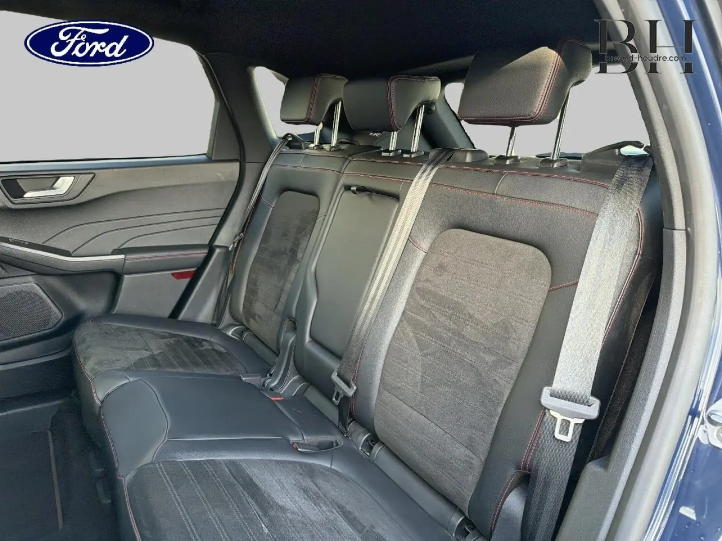Vue intérieure côté droit sur la banquette arrière en tissu noir et simili cuir avec surpiqûres rouges du Ford Kuga bleu 2023.