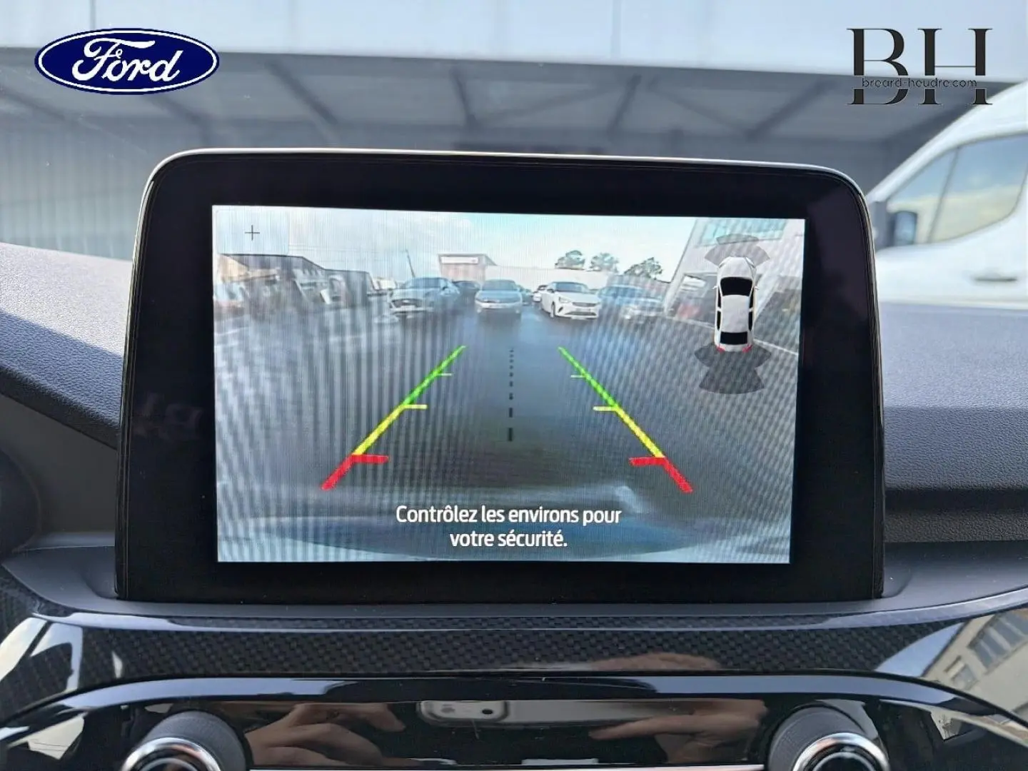 Écran tactile de caméra de recul du Ford Kuga 2023 montrant l’arrière avec guidage coloré, intérieur noir.