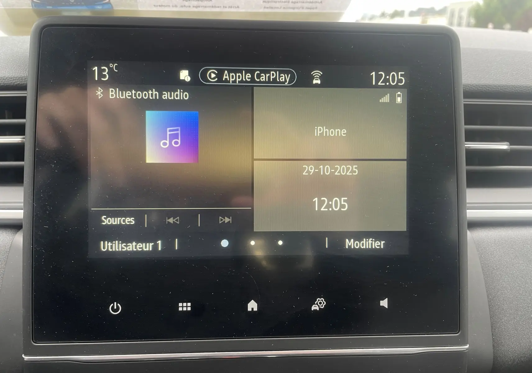 Écran tactile central du tableau de bord d'un Renault Captur bleu métal, affichant Apple CarPlay et Bluetooth audio.