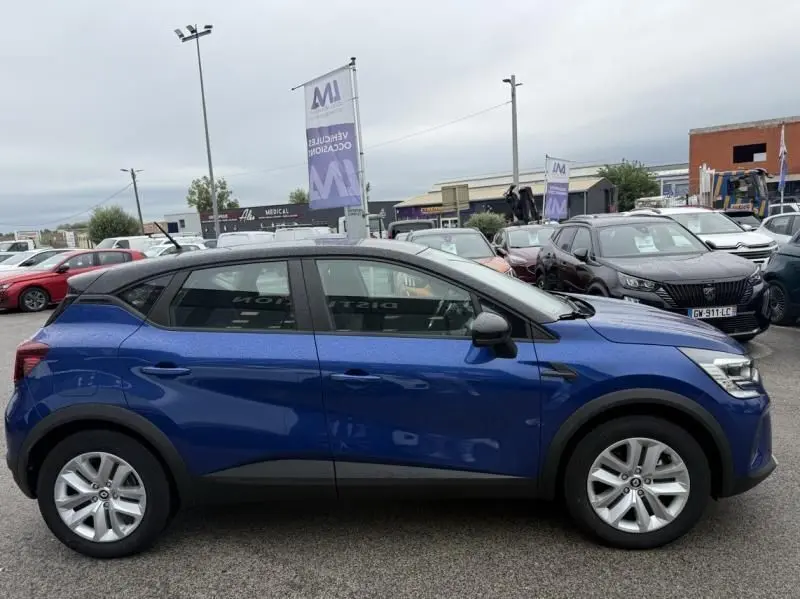 Profil côté gauche d'un Renault Captur E-Tech 145 Zen bleu métal 2022, avec toit noir et jantes argentées.