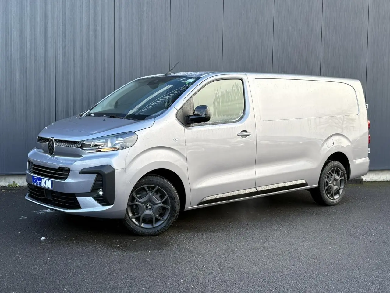 Vue 3/4 avant droite d'un Citroën Jumpy XL gris Artense avec boucliers couleur carrosserie et jantes noires.