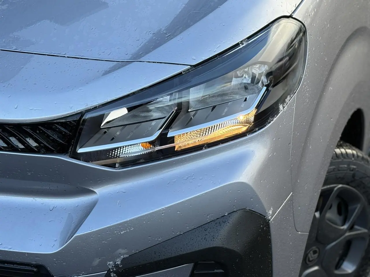 Gros plan sur le phare avant droit gris Artense du Citroën Jumpy XL 2025 avec détails du bouclier noir Perla Nera.