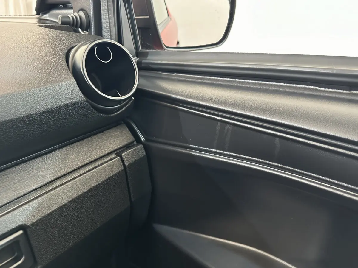 Détail de la porte côté conducteur d'une Aixam Ambition E City Pack 2025 rouge, avec rétroviseur extérieur caméra visible.