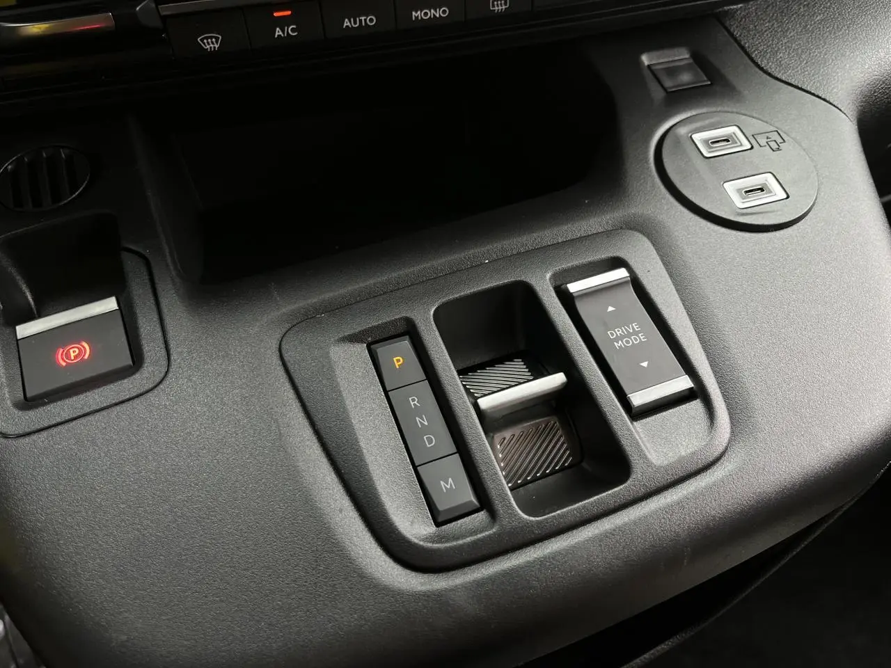 Gros plan sur la console centrale noire du Citroën Berlingo Multispace 2025 avec commandes boîte auto et mode de conduite.