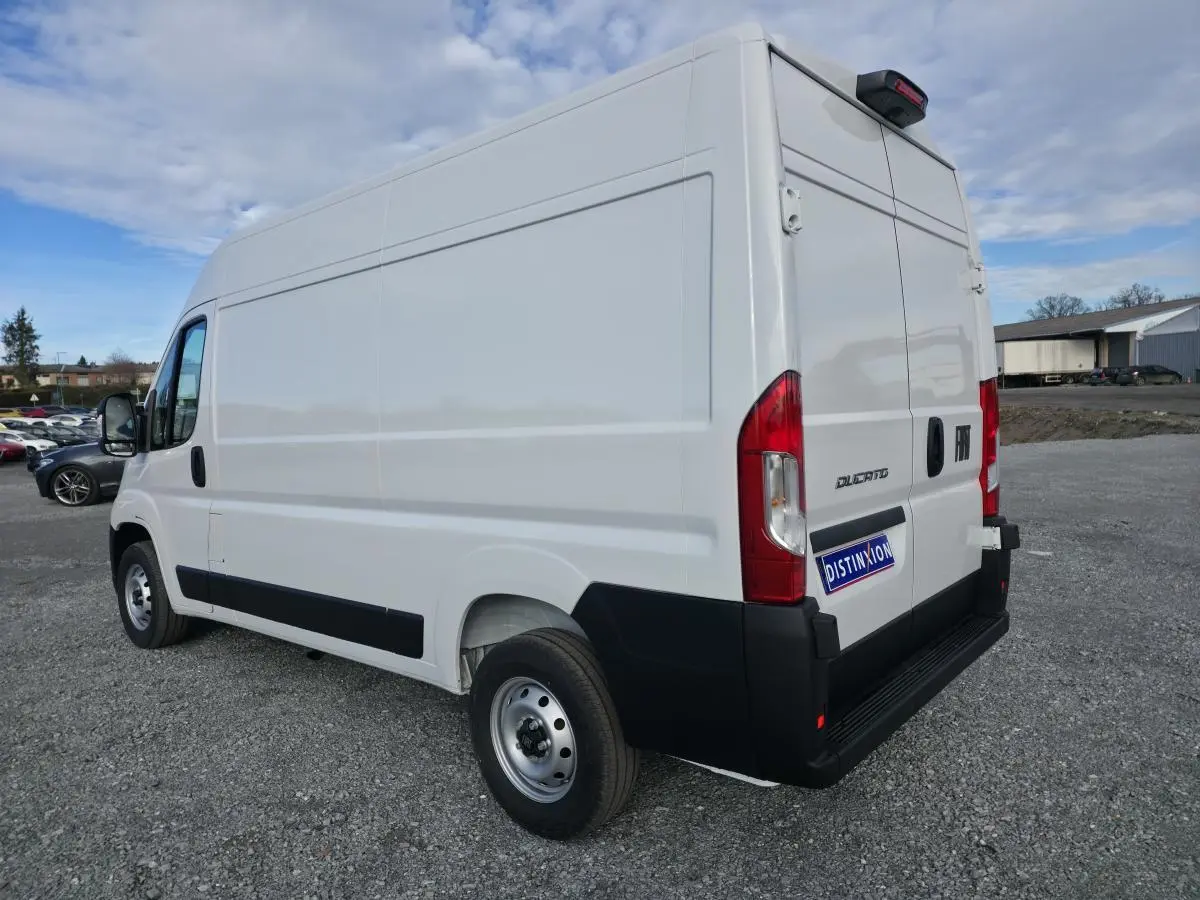 Vue 3/4 arrière droite d’un FIAT Ducato Fourgon blanc avec portes arrière tôlées et porte latérale coulissante.