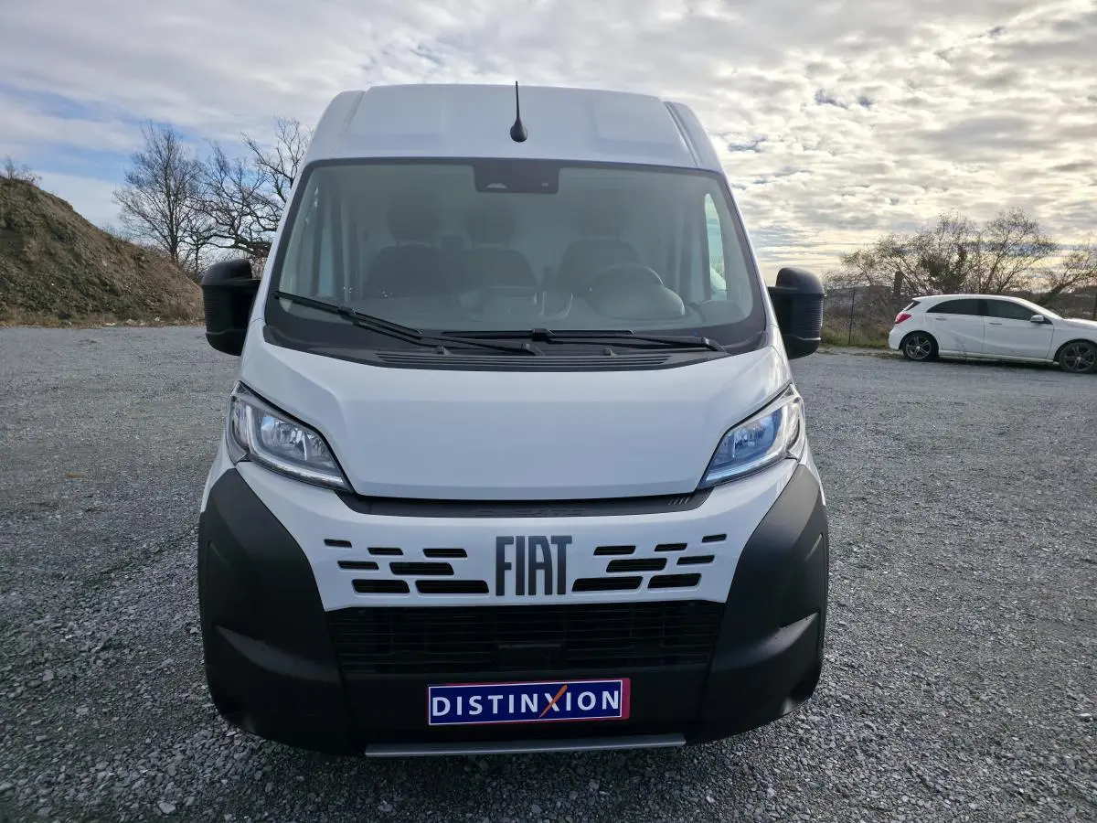 Vue frontale du FIAT Ducato Fourgon blanc 2025 avec pare-chocs noir et logo FIAT bien visible.