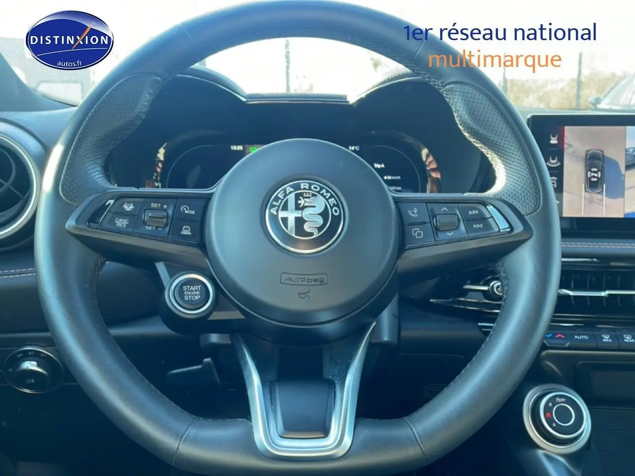 Vue intérieure centrée sur le volant cuir noir de l'Alfa Romeo Tonale 2025 avec tableau de bord digital et écran tactile.