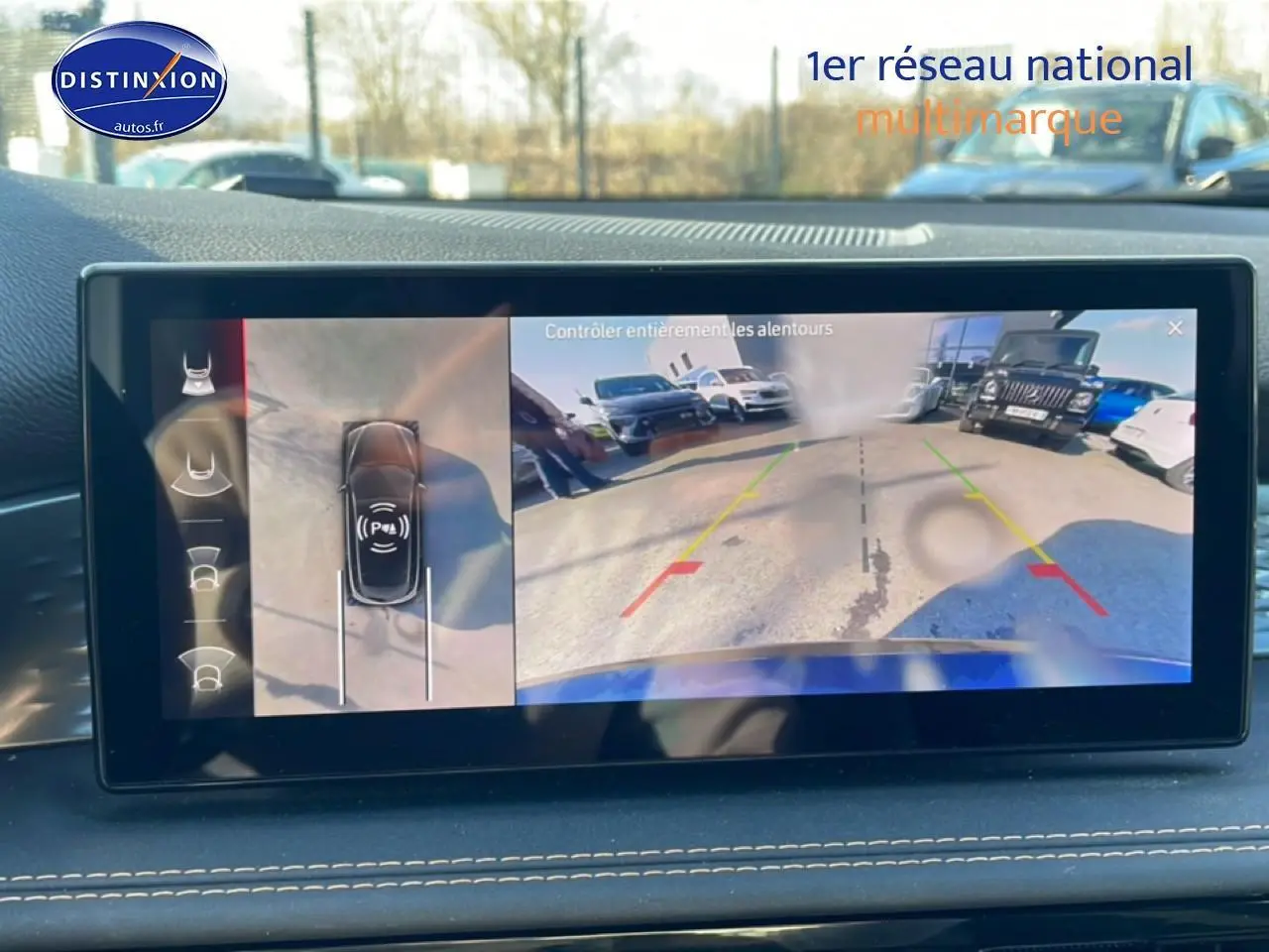 Écran tactile affichant la caméra de recul et vue aérienne du parking autour d'une Alfa Romeo Tonale blanche.