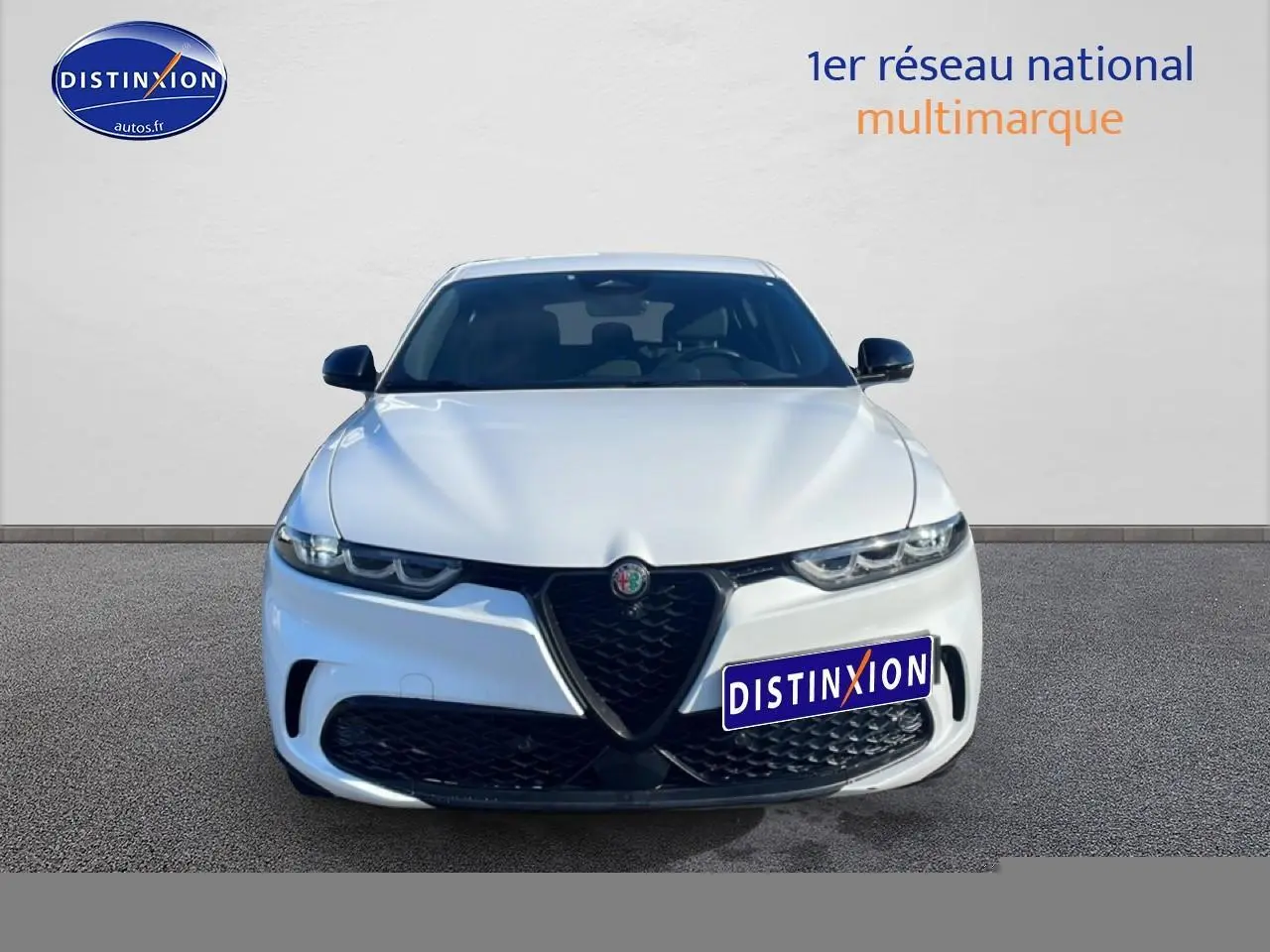 Vue frontale d'une Alfa Romeo Tonale blanche 2025 avec calandre noire et phares LED distinctifs.
