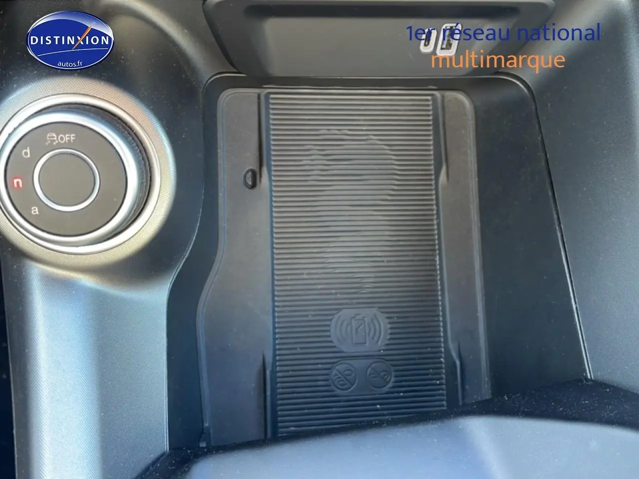 Gros plan sur la console centrale noire de l'Alfa Romeo Tonale 2025 avec zone de recharge sans fil et molette de sélection.