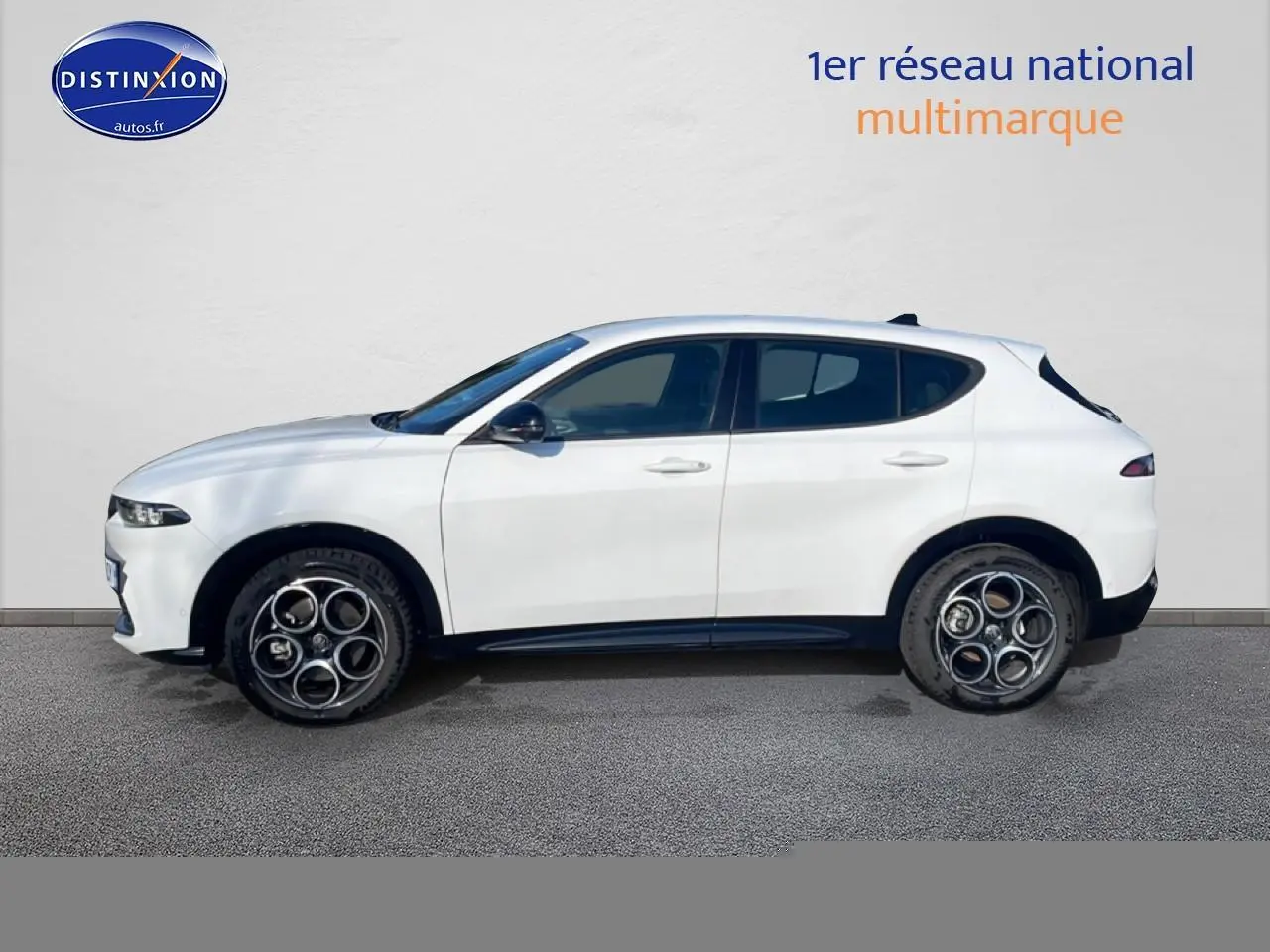 Vue de profil côté gauche d'une Alfa Romeo Tonale blanche avec jantes alu distinctives et lignes épurées.