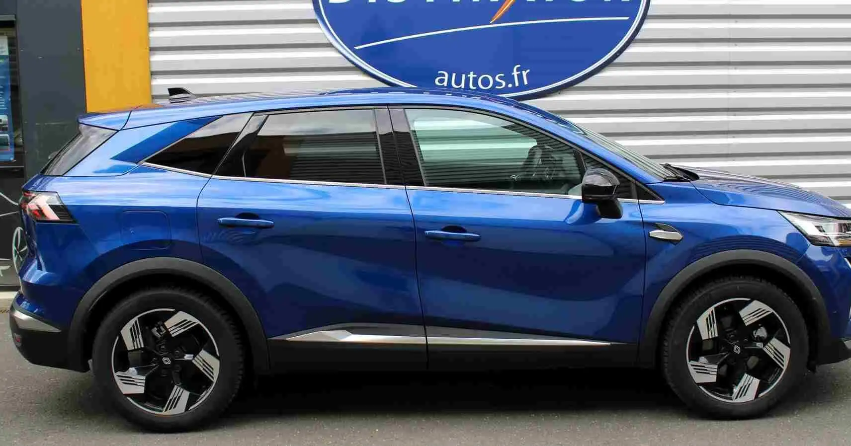 Profil côté gauche du Renault Symbioz 2025 bleu Iron Metal avec jantes noires et détails chromés sous les portières.