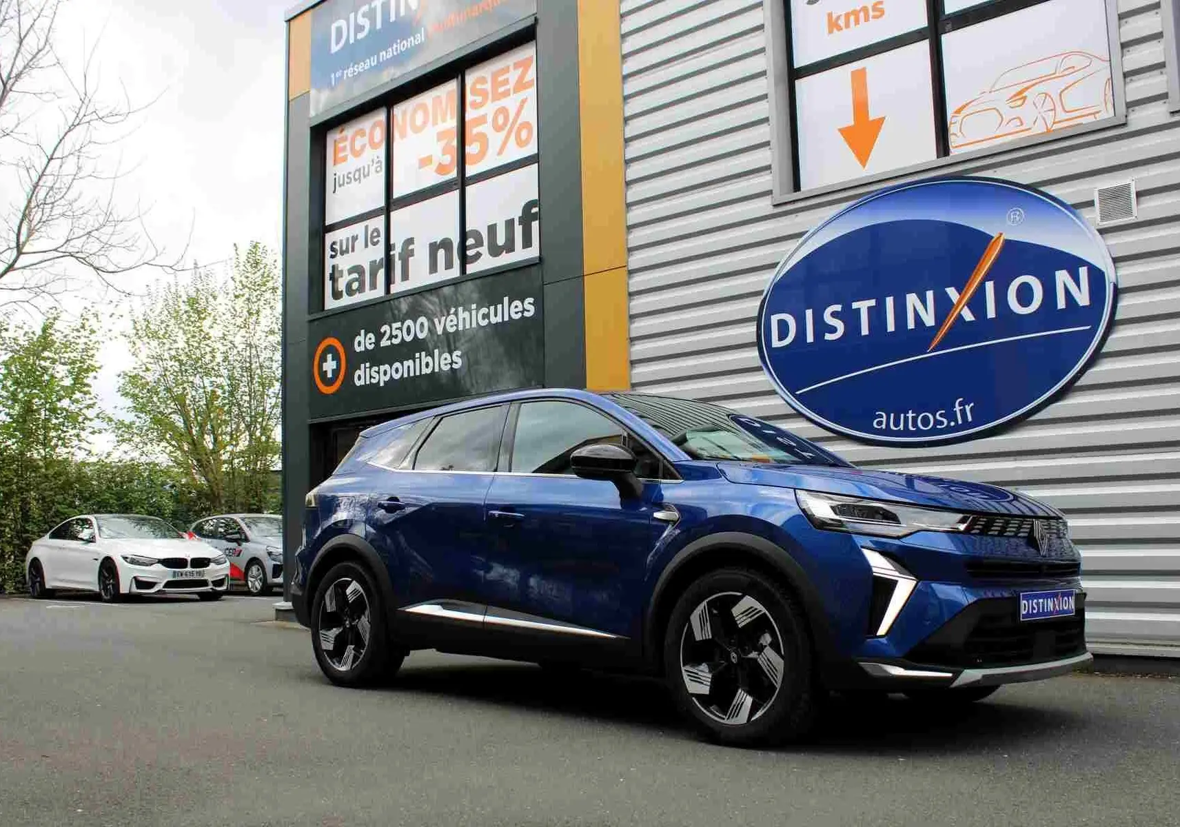 Renault Symbioz bleu iron metal en 3/4 avant droit, SUV hybride avec jantes noires et détails chromés visibles.