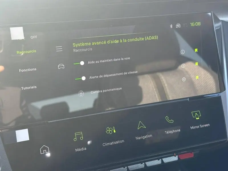 Écran tactile central de la Peugeot 308 rouge Elixir affichant les aides à la conduite avancées (ADAS).