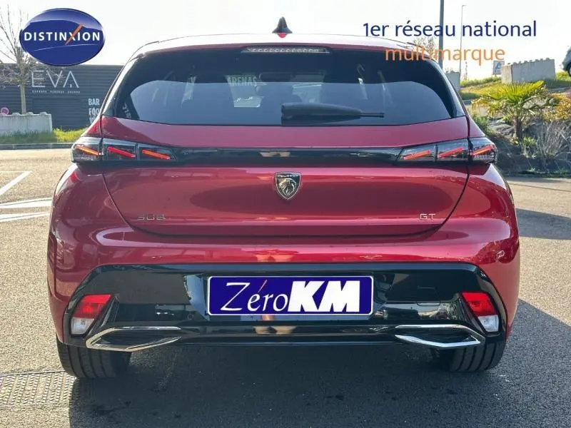 Vue arrière d'une Peugeot 308 GT rouge Elixir avec feux LED et logo lion central sur hayon.