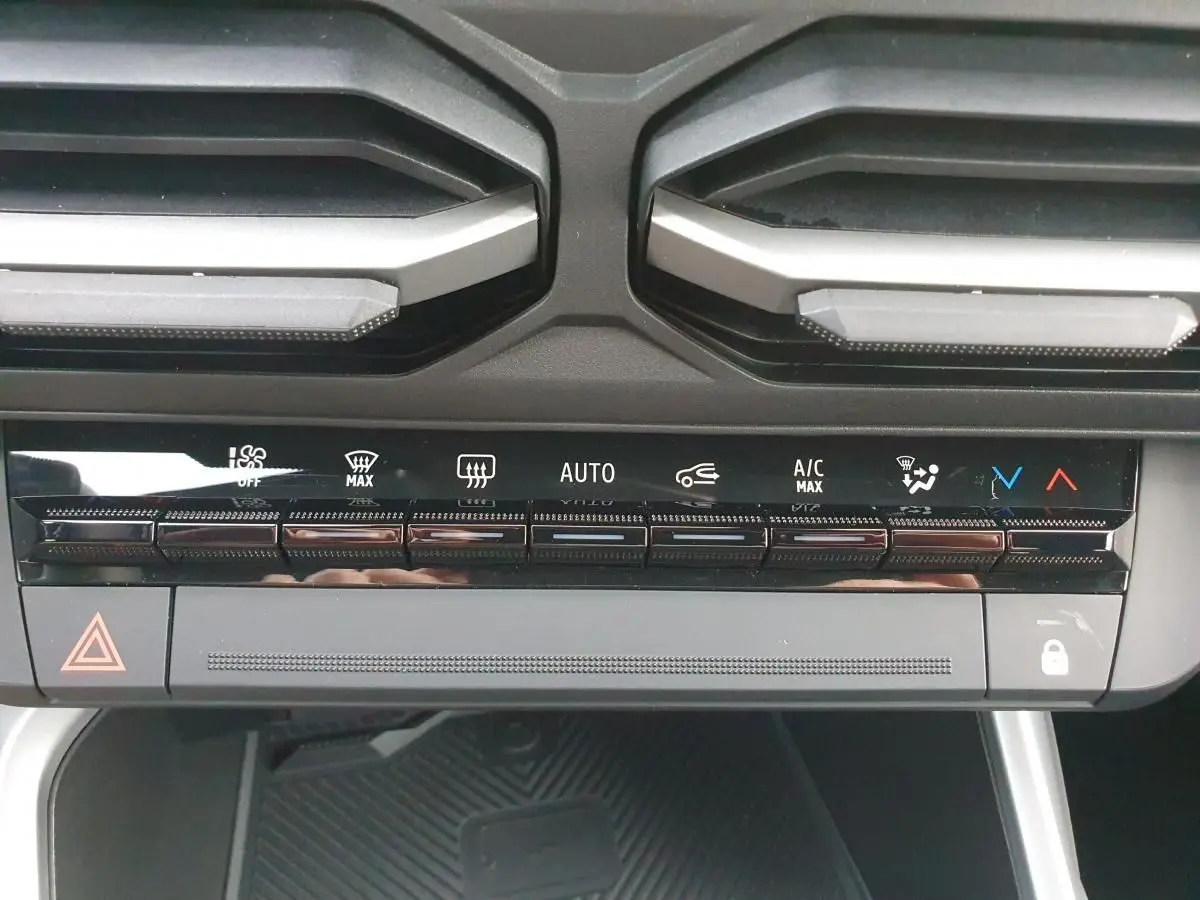 Gros plan sur la console centrale du Dacia Bigster 2026, montrant les commandes de climatisation automatique et les aérateurs noirs.