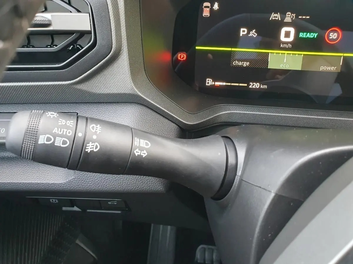 Gros plan sur le commodo des feux et tableau de bord numérique du Dacia Bigster 2026, intérieur noir.