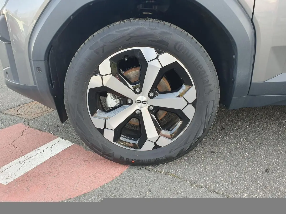 Gros plan sur la roue avant droite du Dacia Bigster gris schiste avec jante alliage 18” diamantée Tagasan.